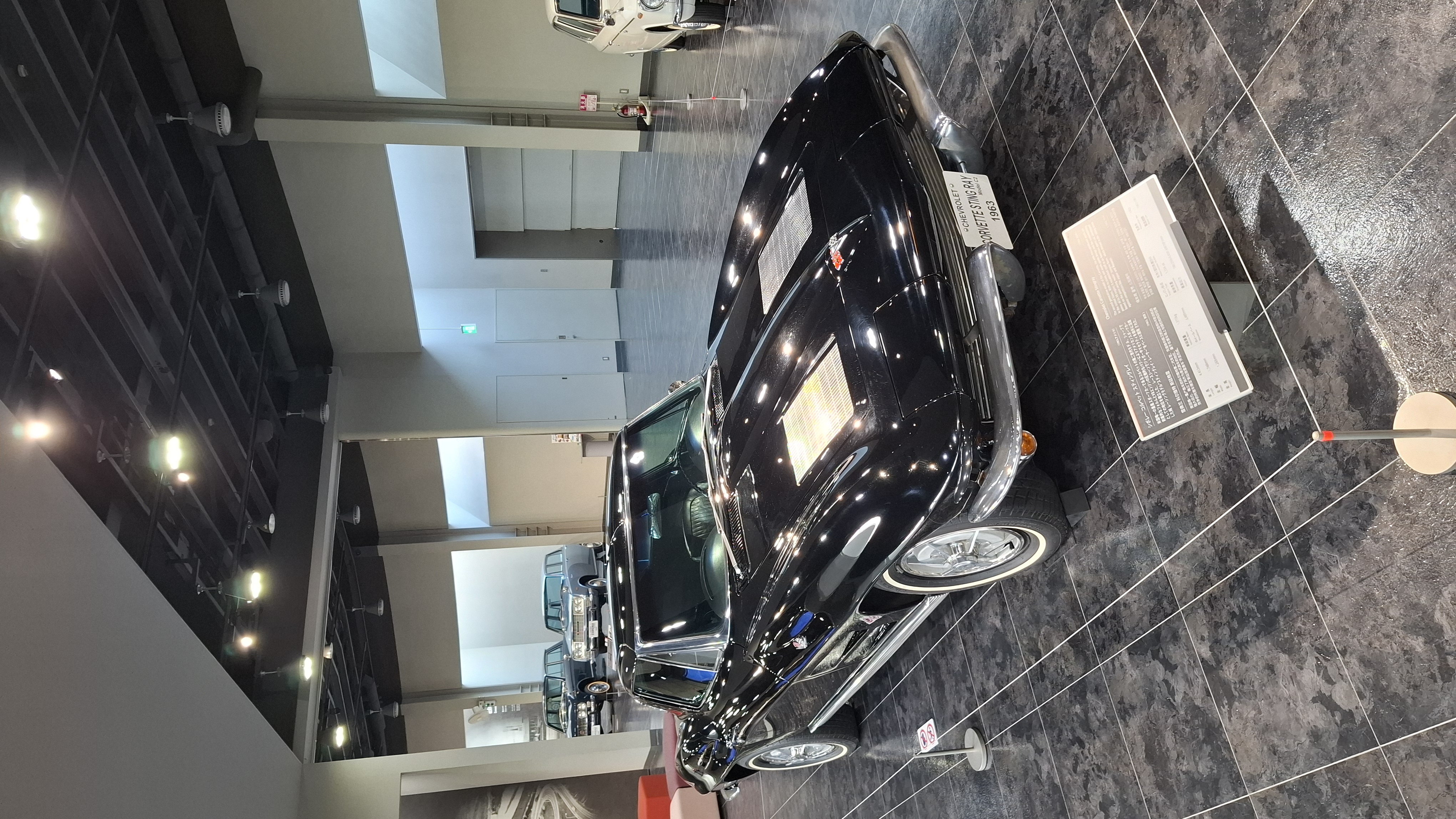 Black 1960s sedan on the museum floor, unidentified European model with chrome trim