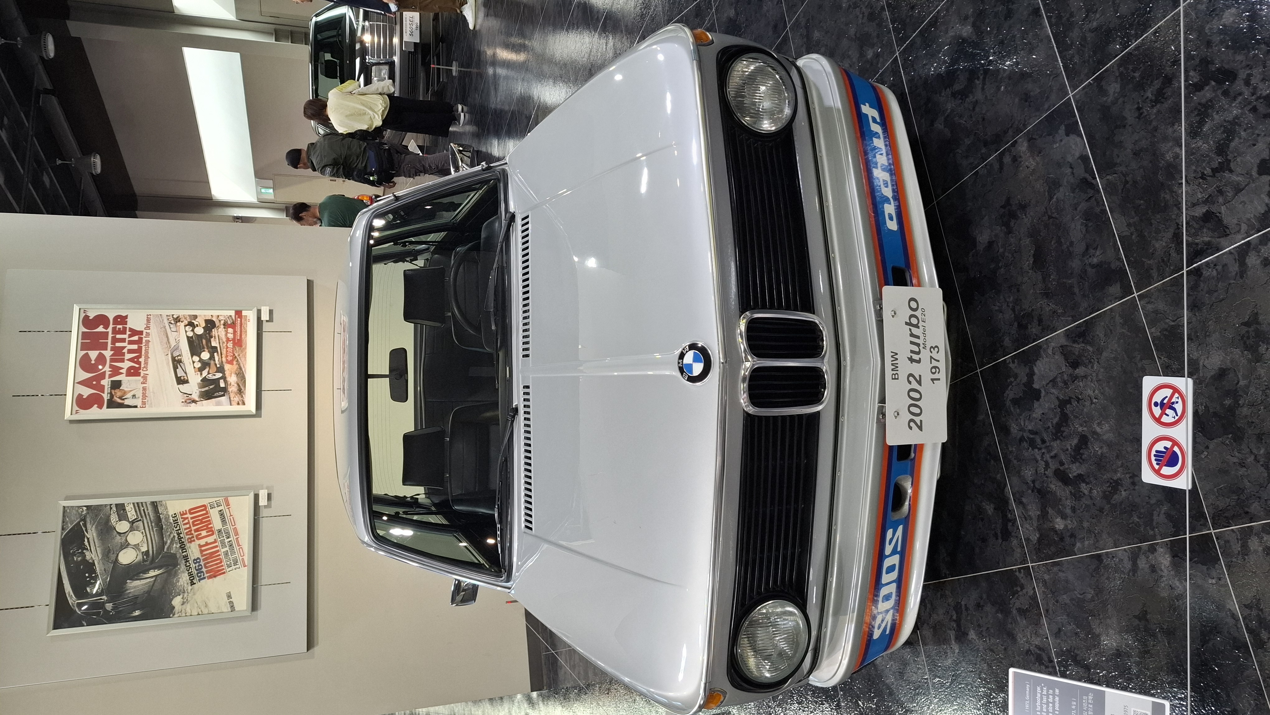 BMW 2002 Turbo front view with reversed Turbo lettering on the front spoiler, Sachs rally posters behind