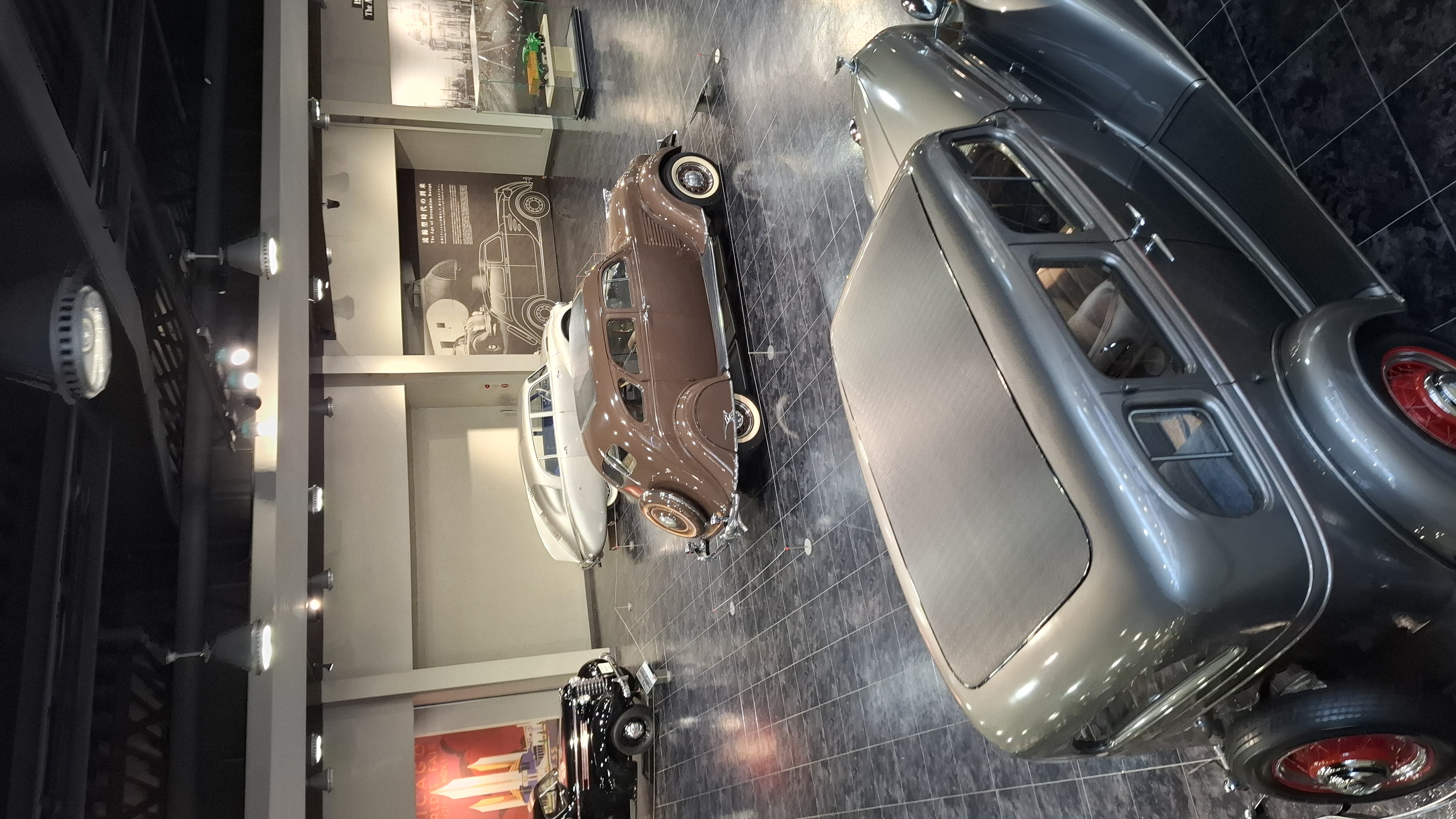 Overview of the museum floor from above: pre-war cars in the foreground, post-war rows stretching back