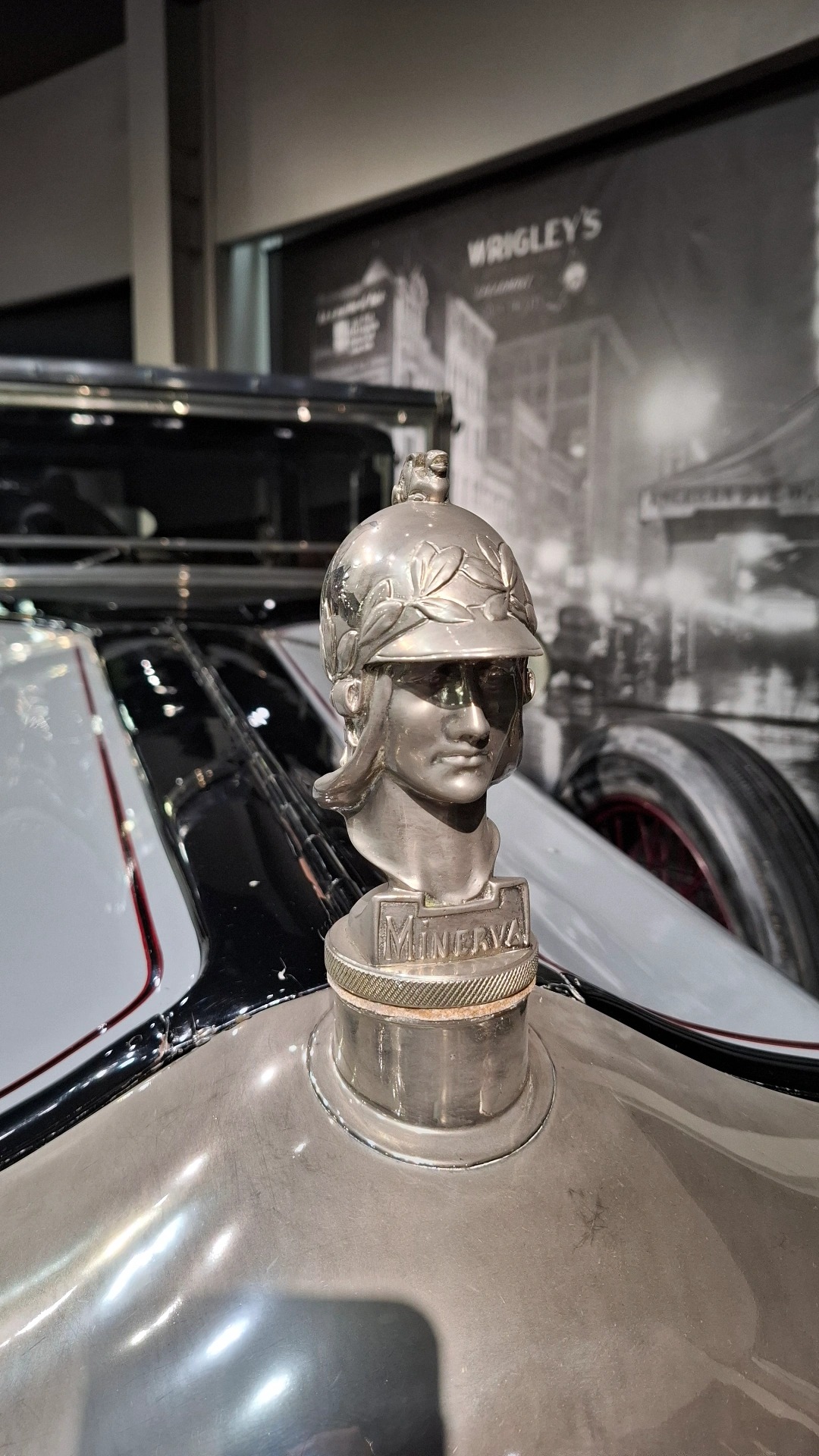 Minerva hood ornament: silver helmeted warrior bust, Wrigley's billboard photograph behind