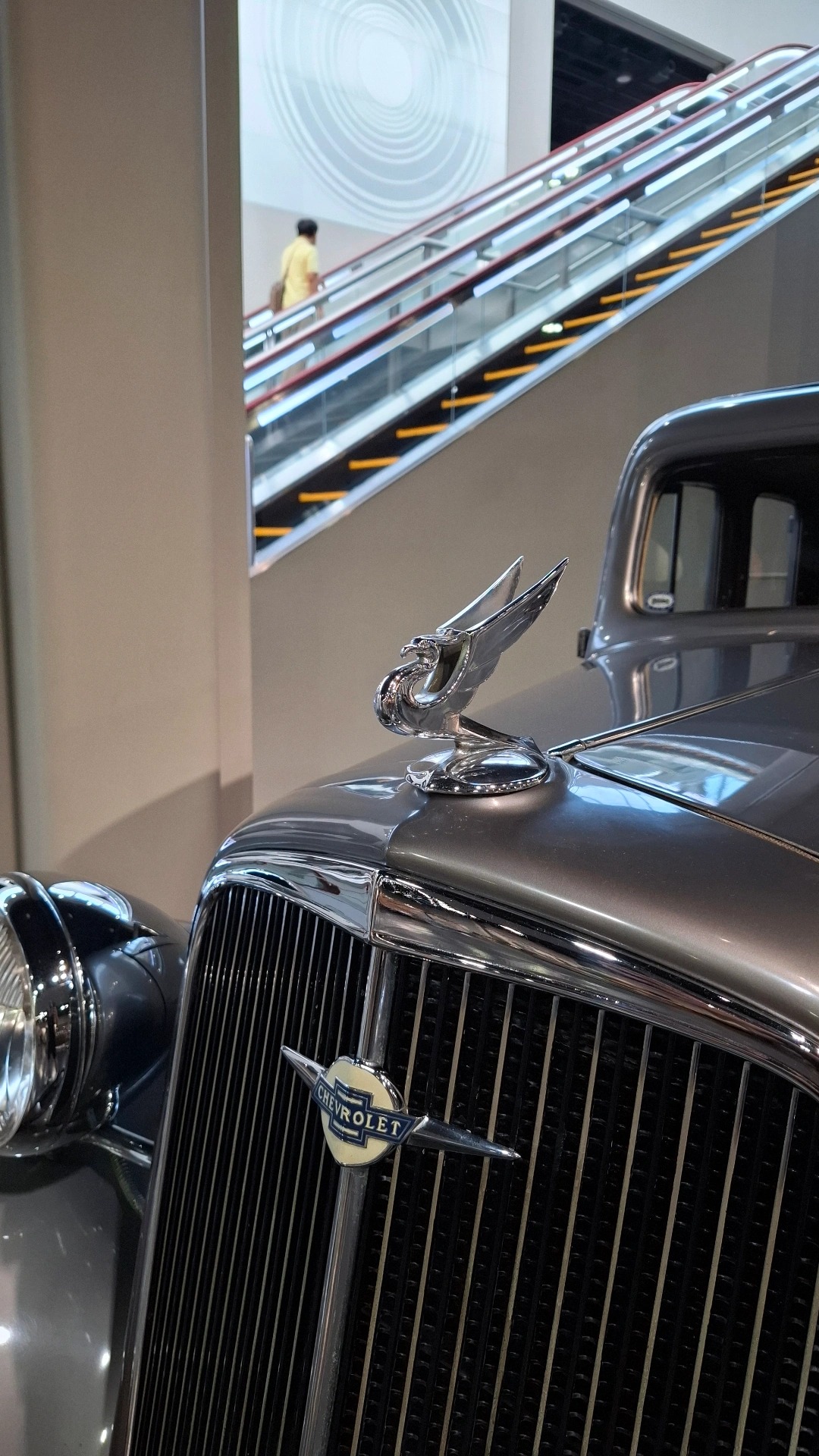 Chevrolet Master eagle hood ornament with museum escalator ascending behind it